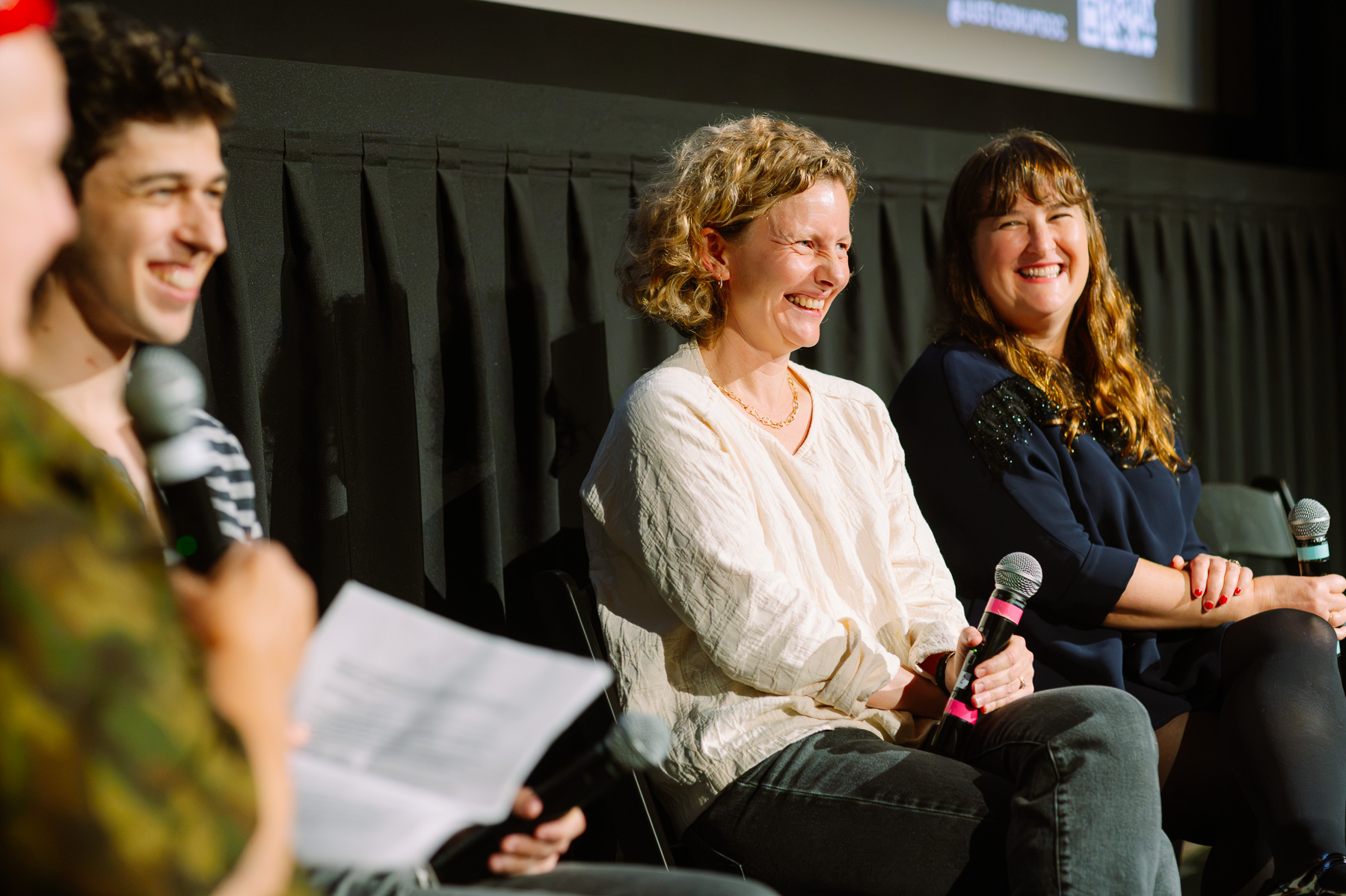 Panelists laughing on stage at the Metrograph
