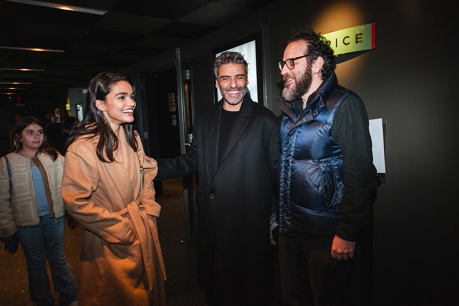 Three guests sharing a laugh in the hallway
