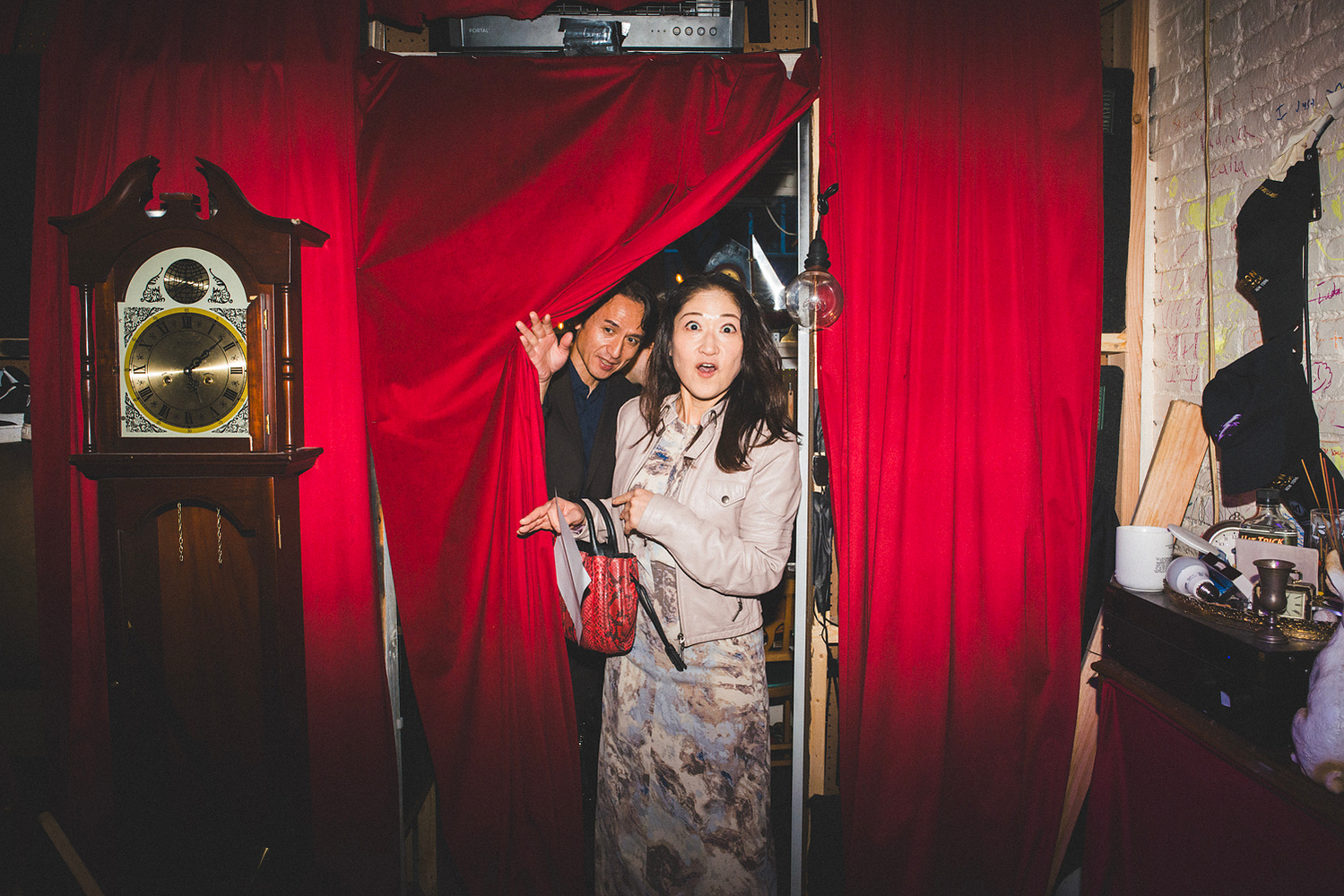 Guests bursting laughing through the red curtain