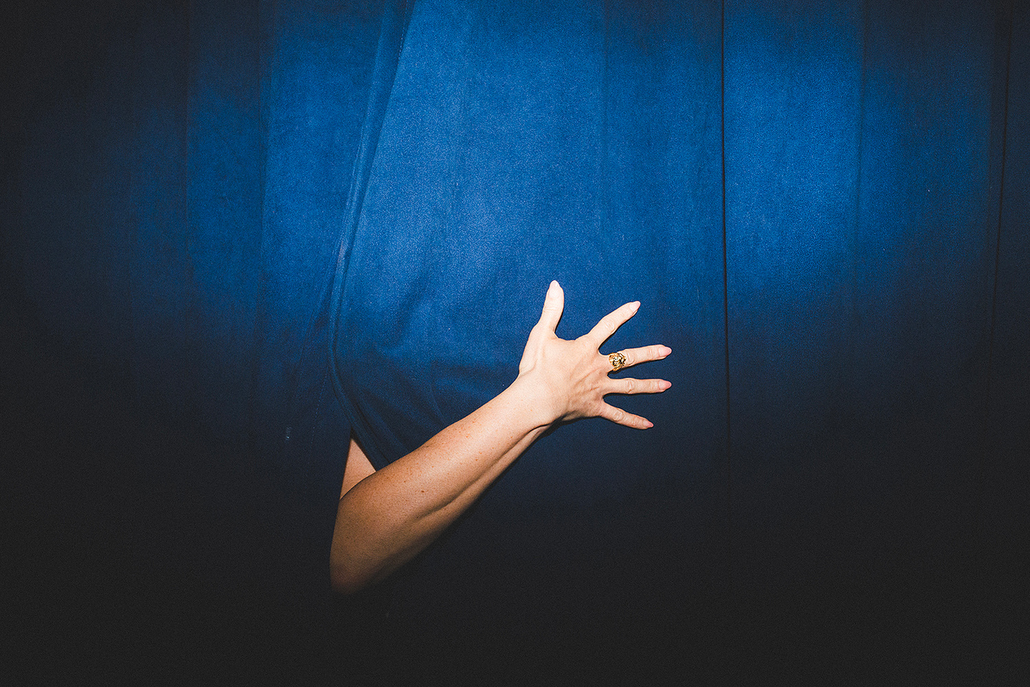 Detail of a hand against the velvet curtain