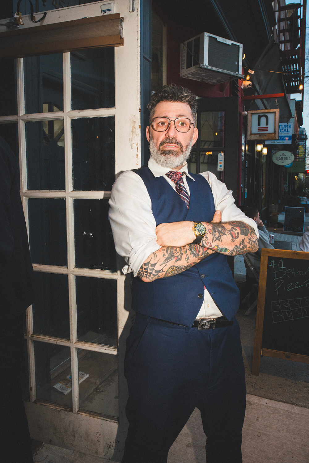 The magician posing in the shop doorway at dusk