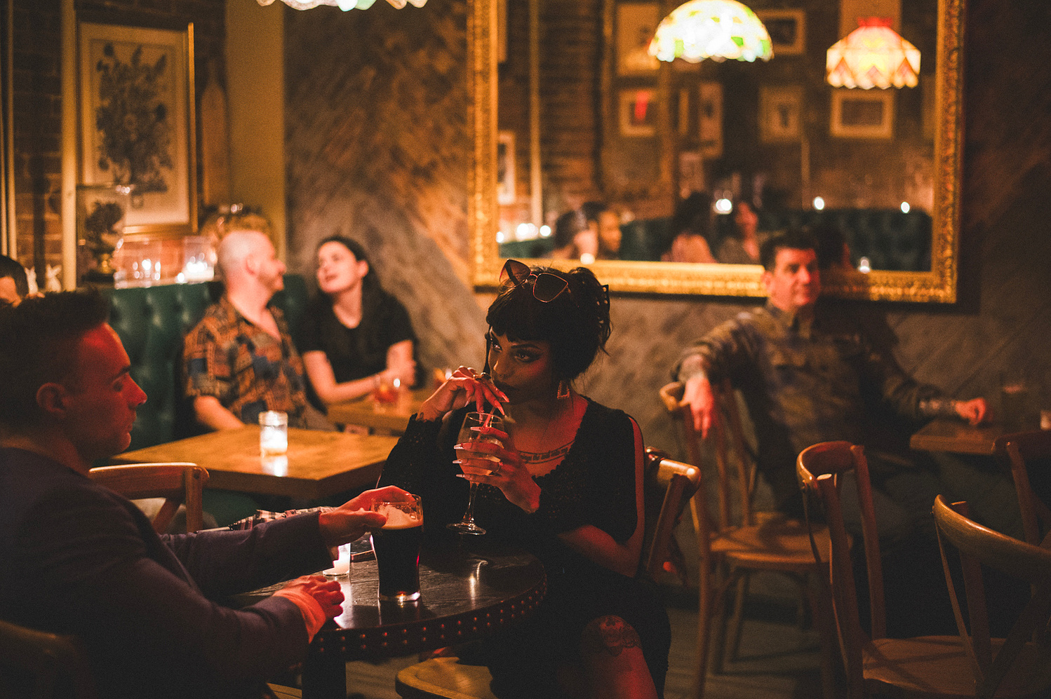 Guests at a tavern table with cocktails