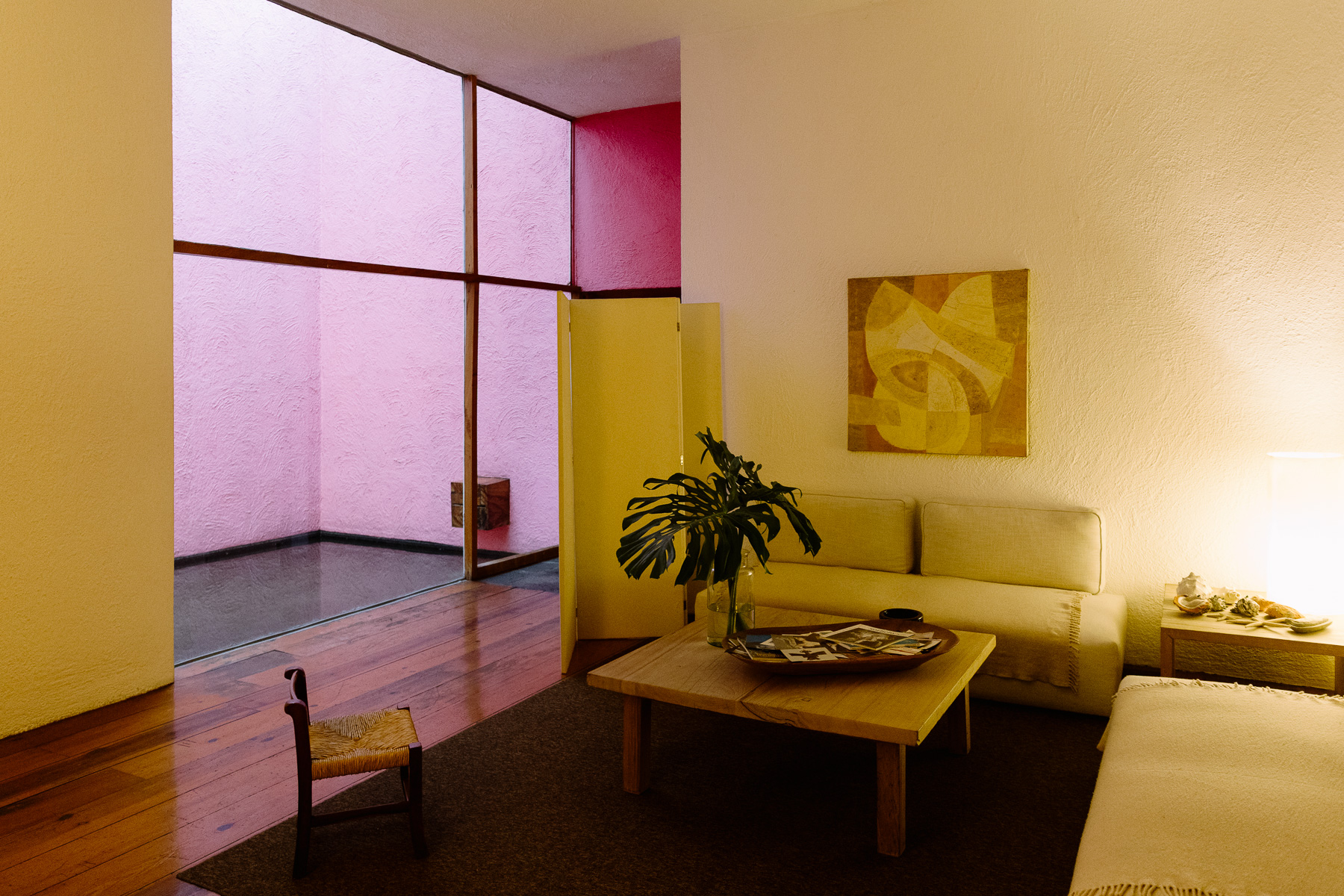 Salon at Casa Gálvez with the pink courtyard window behind the yellow sofa