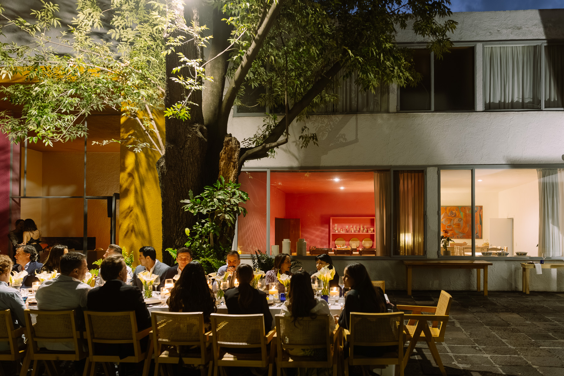 Dinner under the trees in front of the lit house
